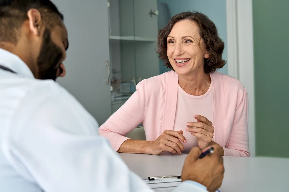 Senior woman smiling during a consultation with a doctor.