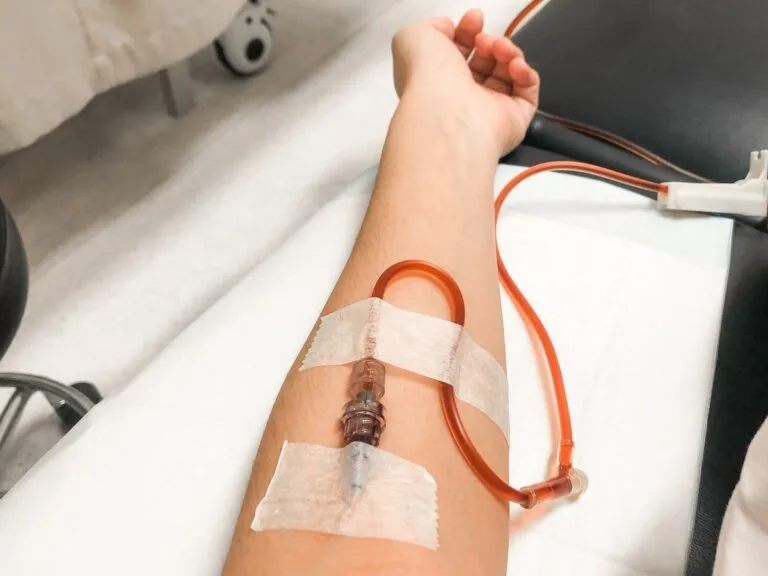 An arm with a medical tube administering an iron infusion, representing the therapeutic benefits for anemia patients.