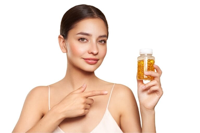 A woman holding a bottle filled with vitamin E capsules, pointing at it with a smile, emphasizing nutritional supplements for health.