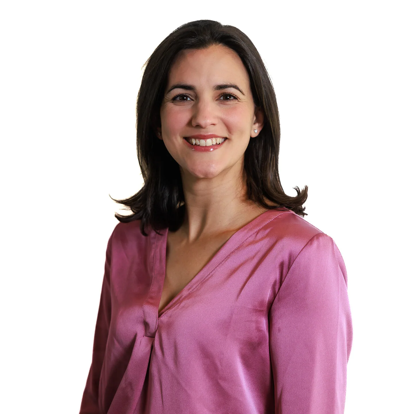 Smiling woman in a pink blouse with dark hair against a white background.