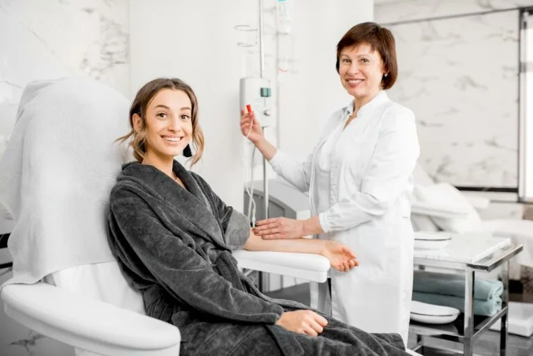 Woman receiving intravenous therapy from nurse