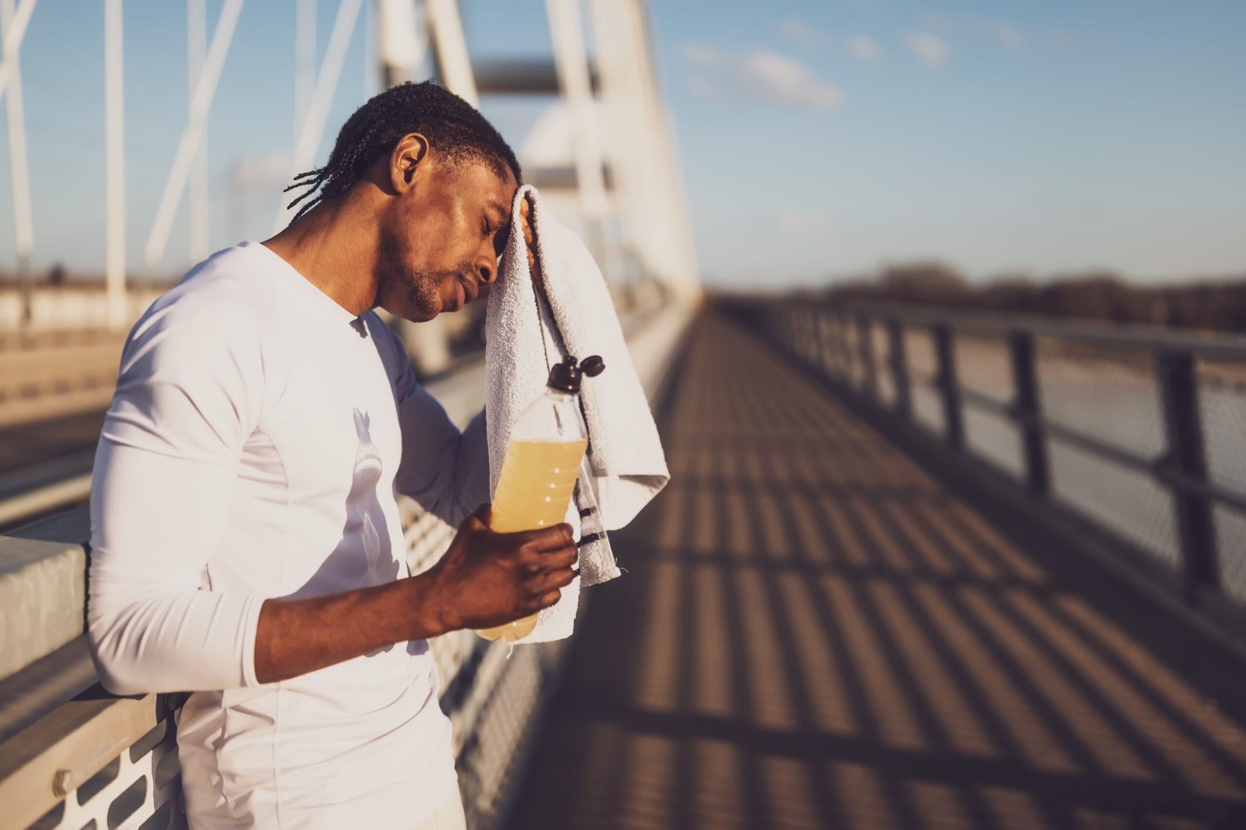 Man on bridge with coffee and phone