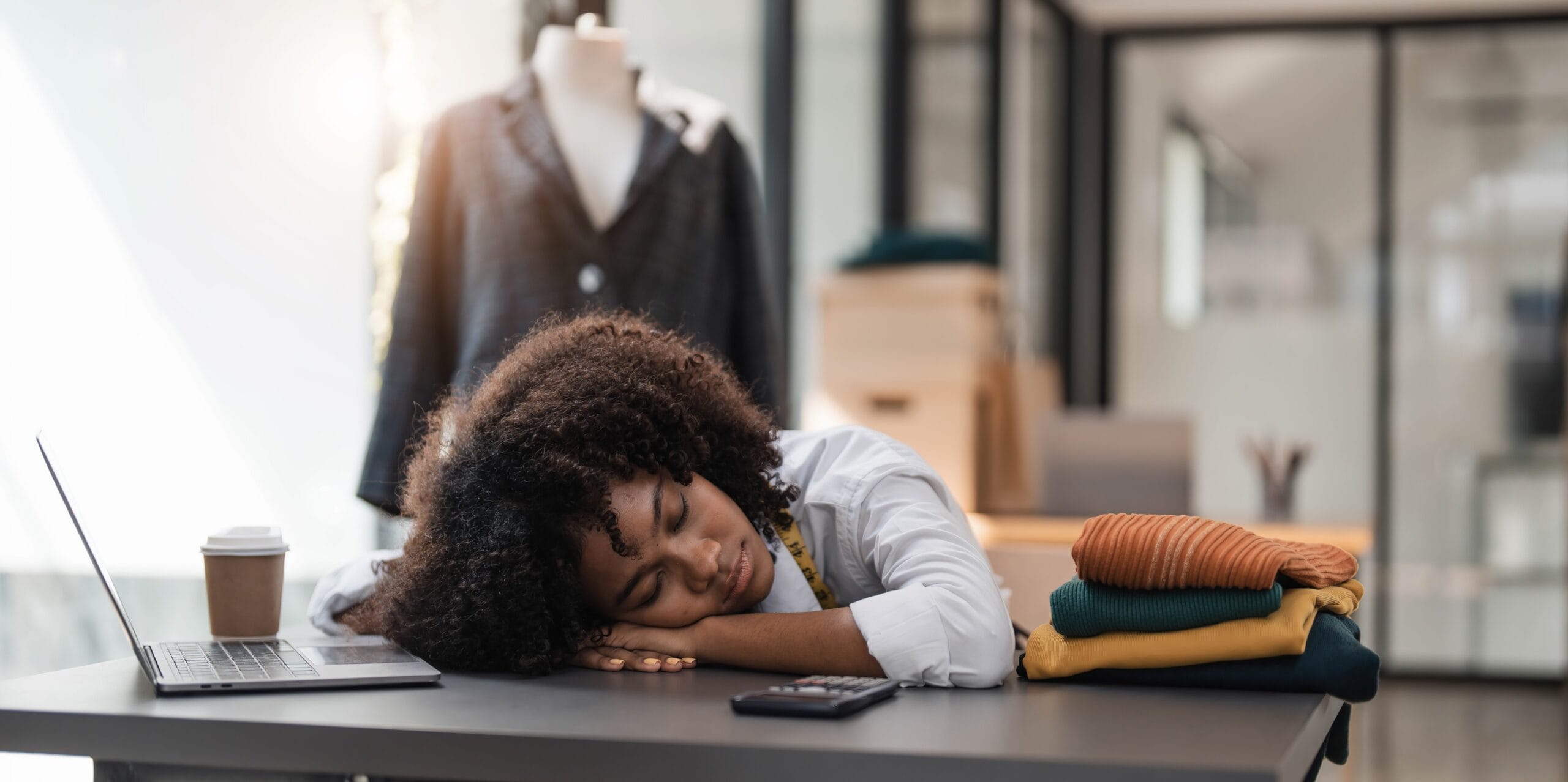 Woman resting head on desk in design studio
