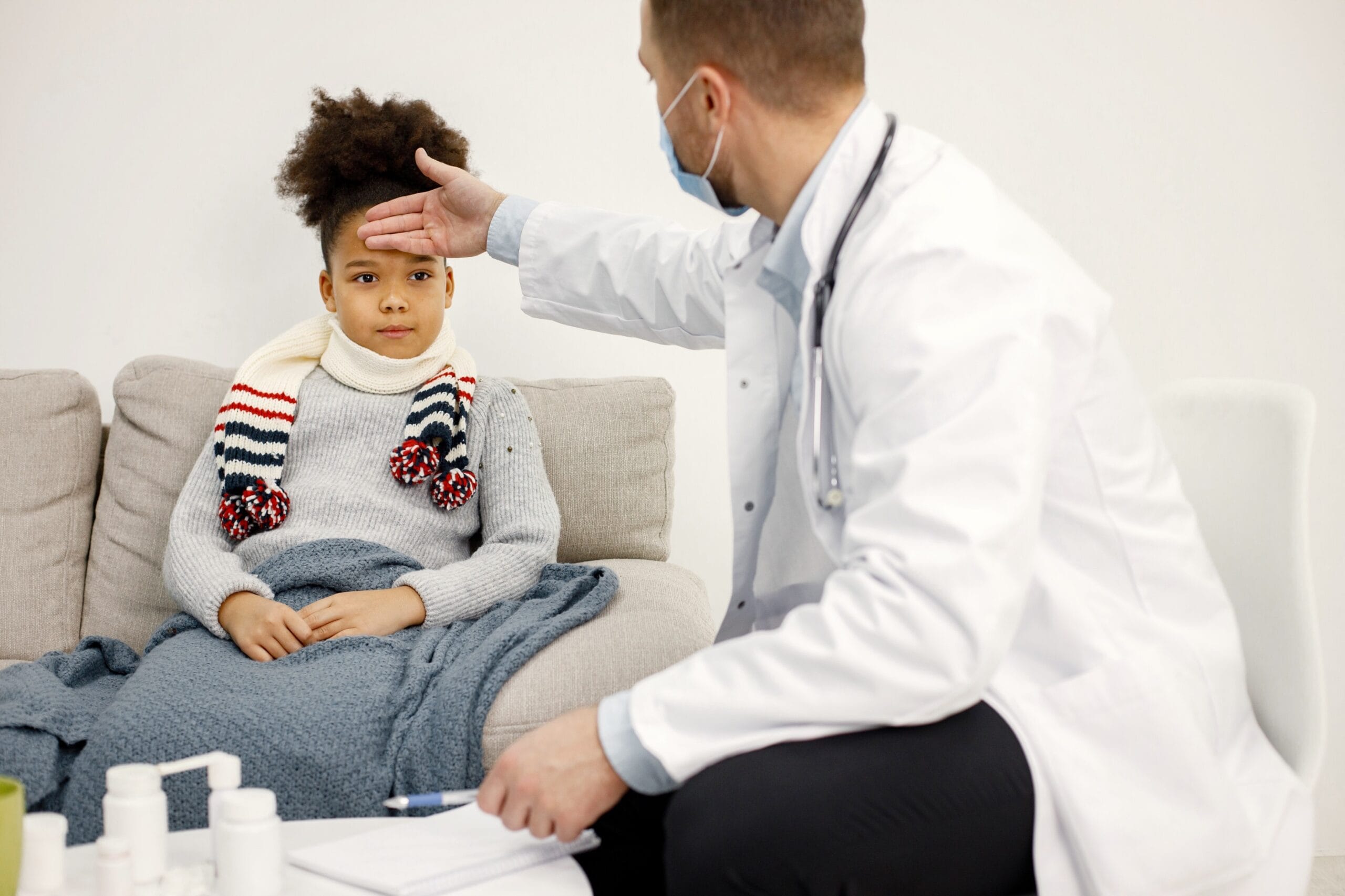 Doctor checking child's forehead for fever