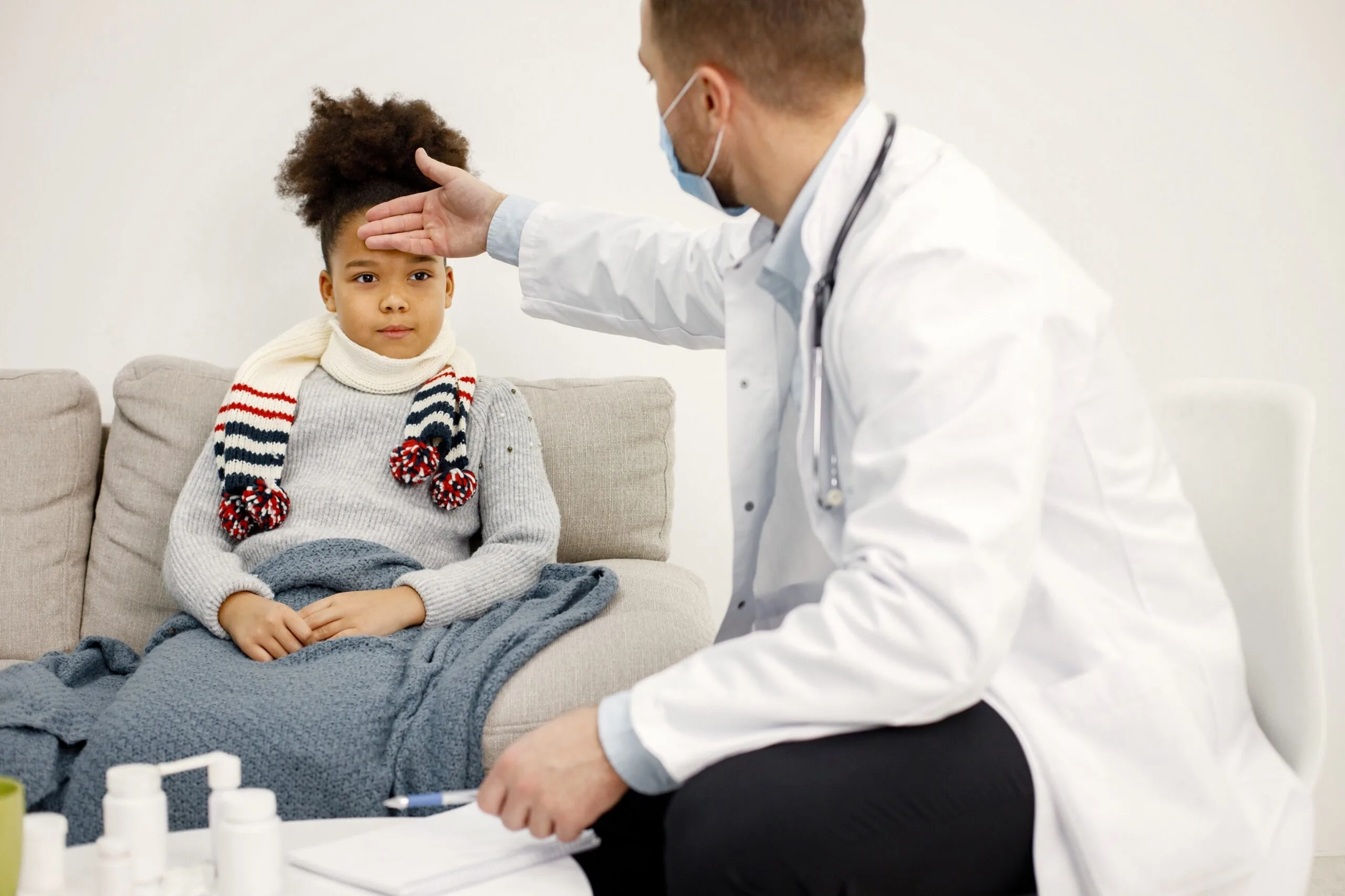 Doctor checking child's forehead for fever