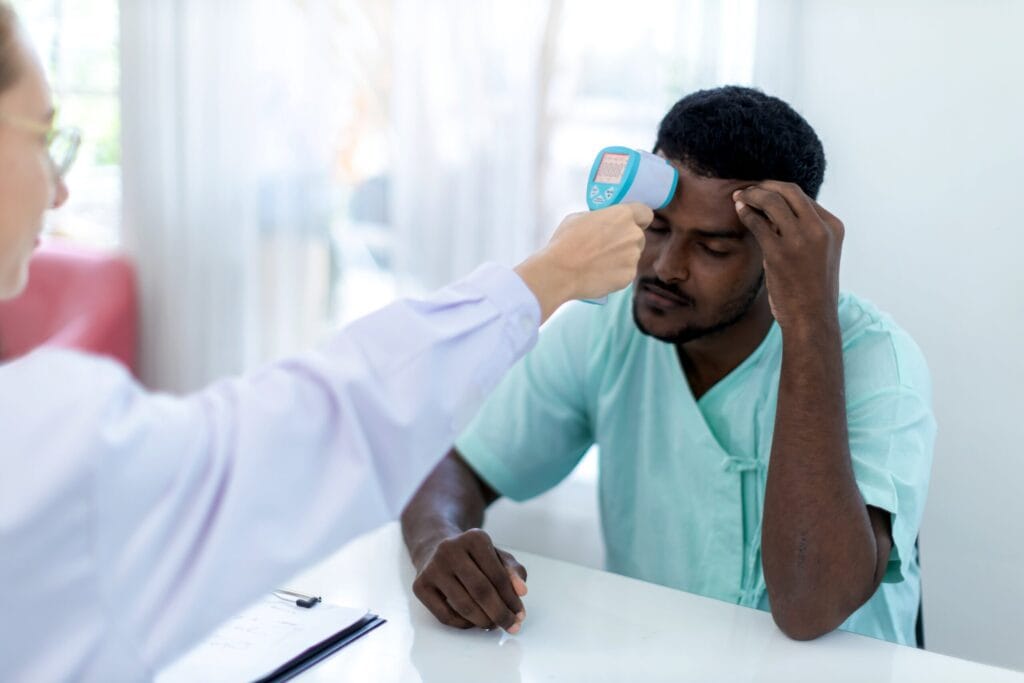 Patient forehead temperature check with thermometer
