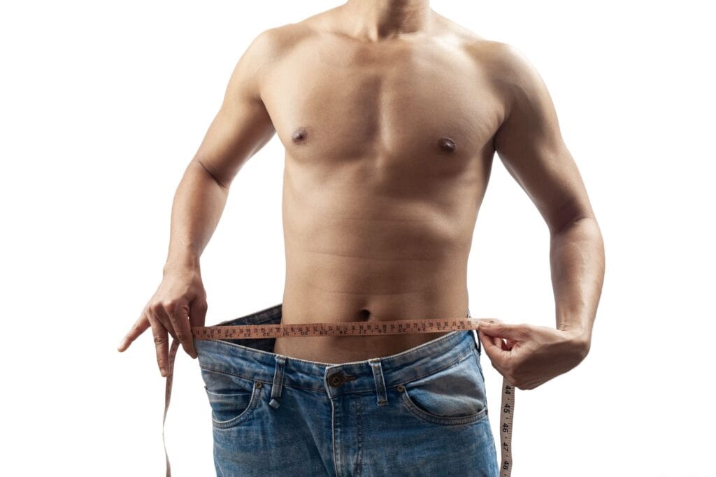 Man measuring waist with tape and loose jeans