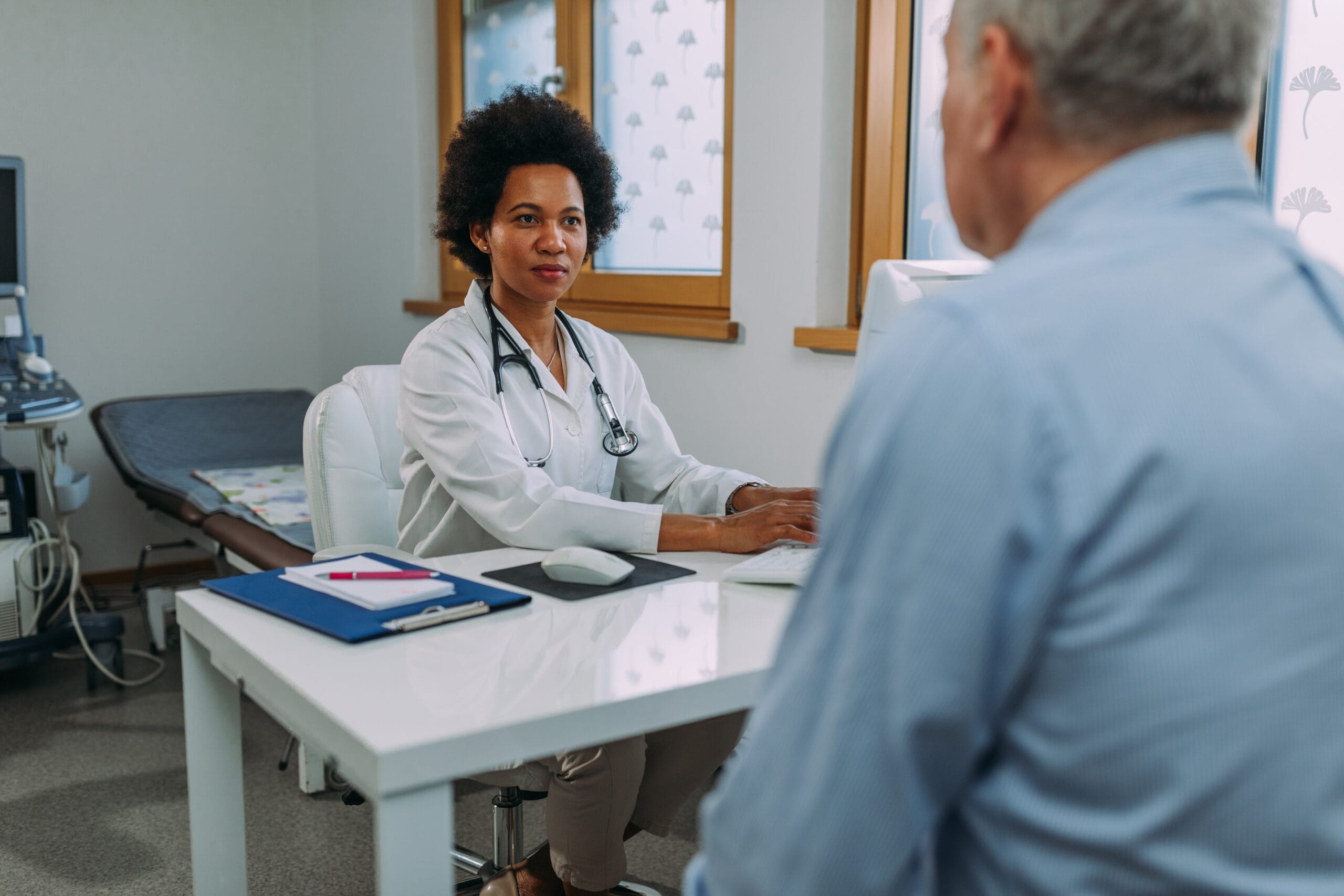 Doctor talking to elderly male patient