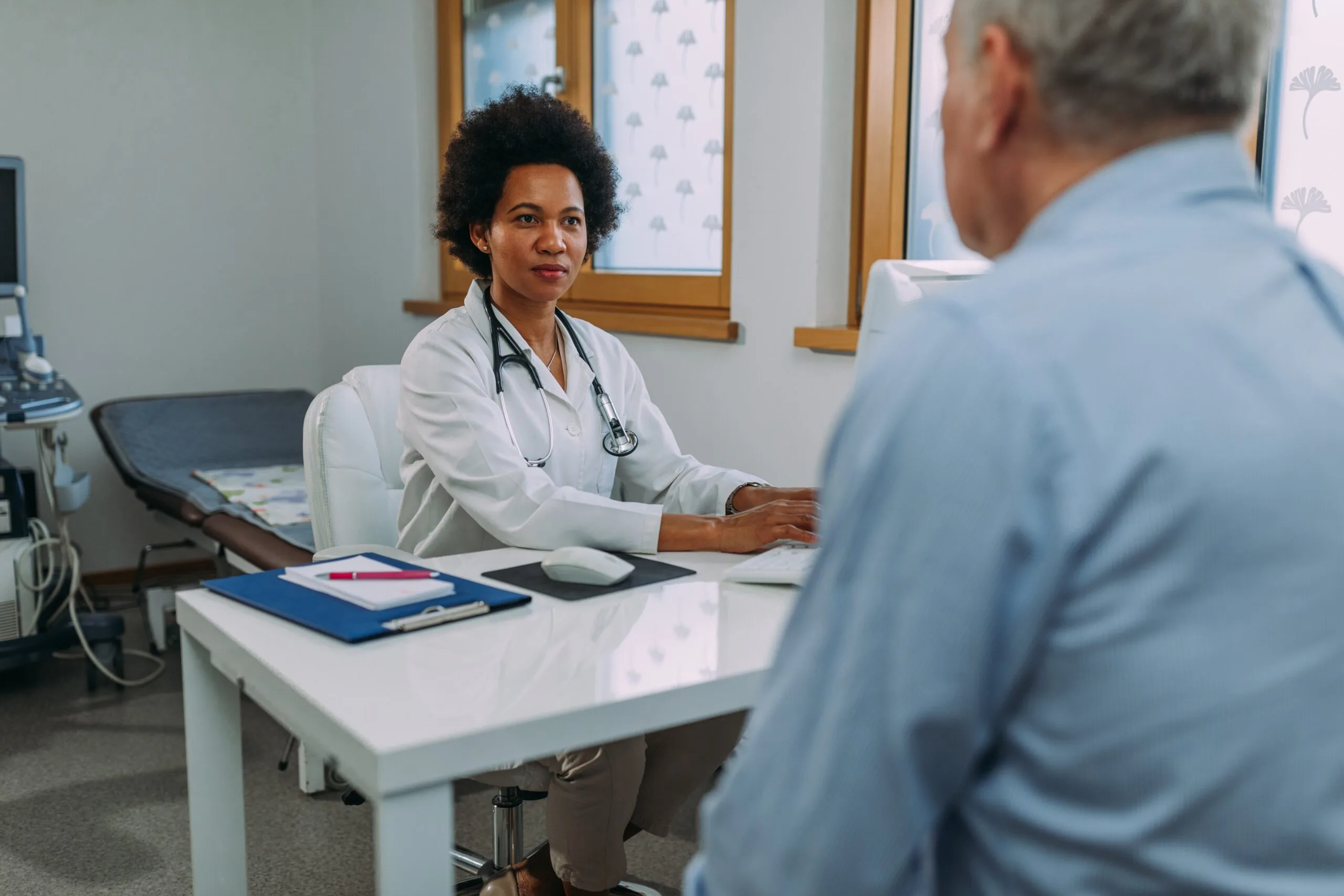 Doctor talking to elderly male patient