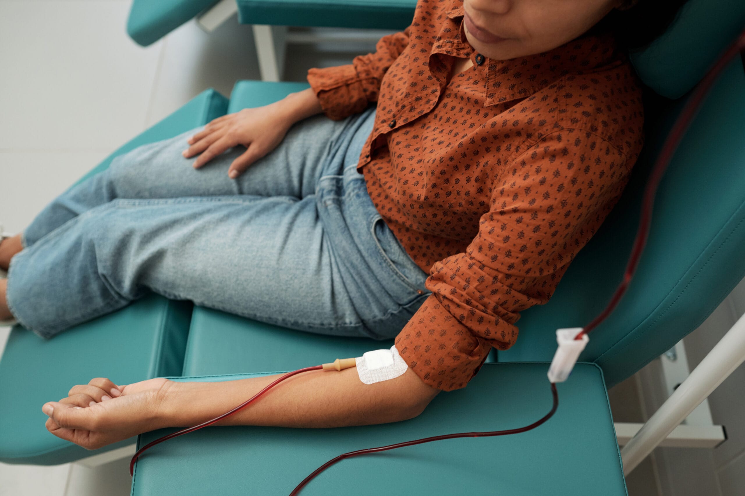 Woman donating blood in medical chair